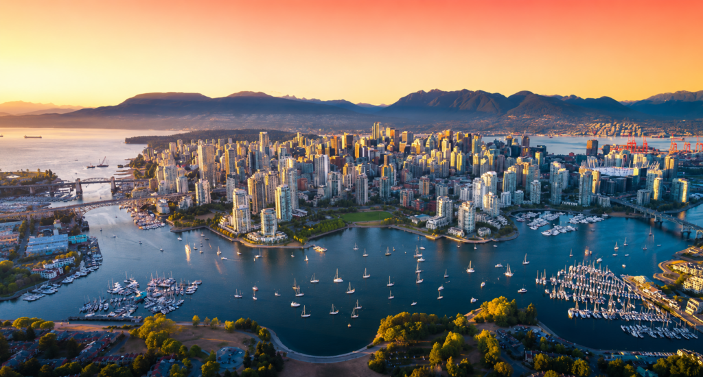 Aerial view of Vancouver's skyline at sunset, showcasing the waterfront and mountains, ideal for Bellevue Limousine Service.